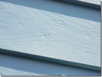 Close inspection reveals small dents in siding due to hail